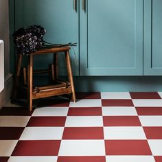 a kitchen with blue cabinets and red and white checkered flooring on the floor