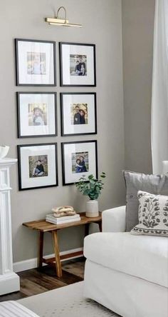 a living room with white furniture and pictures on the wall above it's fireplace