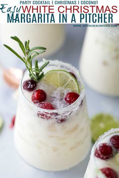 margarita in a pitcher with cranberries and limes on the rim, garnished with rosemary