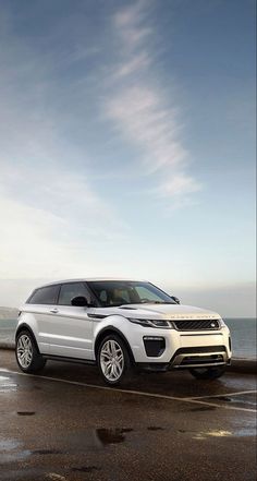 a white range rover parked on the beach