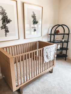 a baby's crib in a room with two pictures on the wall