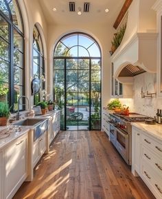 a large kitchen with an arched window and wooden flooring is pictured in this image