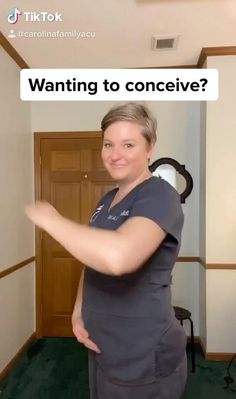 a woman in scrubs is pointing to something on the wall that says, wanting to conceive?