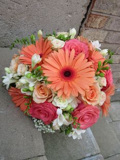 Wedding bouquet of freesia, roses, gerbera daisies and baby's breath in coral, peach and white shades. Designed by Brittany Prom Flowers