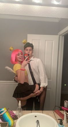 a man and woman taking a selfie in the bathroom