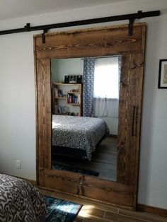 a bed sitting under a mirror in a bedroom