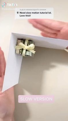 someone is opening up a small card with the word slow version written on it in white