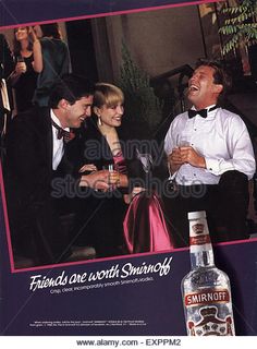 an advertisement for smiroff vodka featuring two men in tuxedos, one holding a drink and the other smiling - stock photo