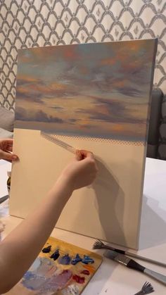 a person is painting an image on a canvas
