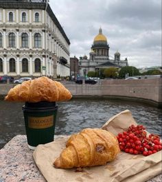 croissants and berries sit on a napkin next to a cup of coffee