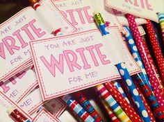 there are many pens and paper signs on the table with writing written on them for kids to write