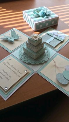 a table topped with lots of cards and a cake on top of each card holder