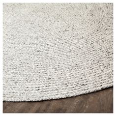 a white rug on top of a wooden floor