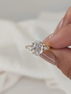 a woman's hand holding an engagement ring