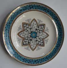 a blue and white plate with an ornate design on the rim, sitting on a table