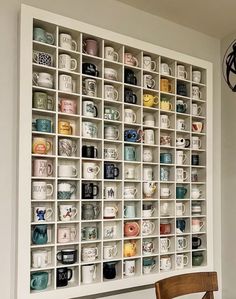there is a wall full of coffee mugs on the shelves in this room,