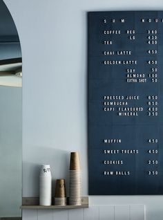 the menu is displayed on the wall next to two vases