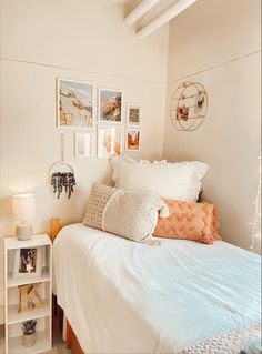 a bedroom with white walls and pictures on the wall