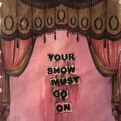 a pink stage curtain with the words your show must go on written in black ink