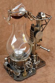 an old fashioned coffee machine with a glass carafe on it's top and steam engine underneath