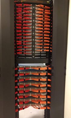 the inside of an electrical cabinet with many orange and black wires in it's center