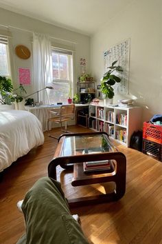 a living room filled with furniture and a wooden floor covered in lots of bookshelves
