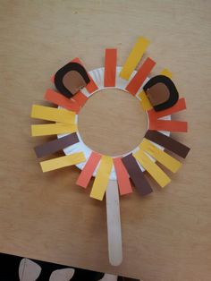 a paper circle made to look like an animal's head with strips of construction paper on it