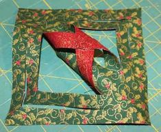 an origami piece with a red ribbon in it