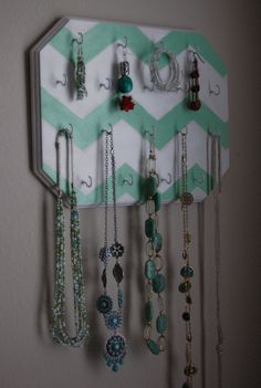 a wall mounted jewelry holder with several necklaces