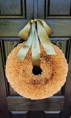 a wreath with a bow hanging on the front door