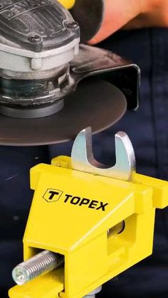 a close up of a person using a circular tool on a piece of metal with the topex logo on it