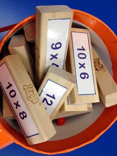 several wooden blocks with numbers on them in a bowl