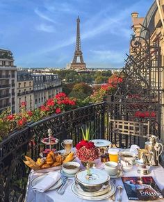 a table with food and drinks on it in front of the eiffel tower
