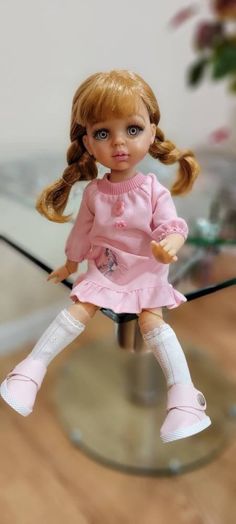 a doll sitting on top of a glass table
