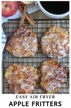 four apple fritters on a cooling rack with cinnamon sticks and an apple in the background