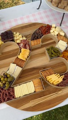a heart shaped cheese platter with many different types of cheeses and crackers
