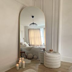 a mirror sitting on top of a wooden floor next to a white couch in a living room
