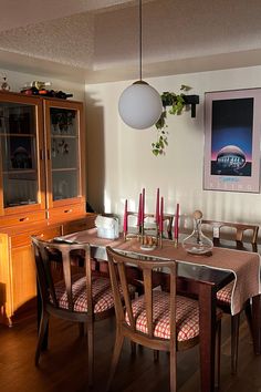 a dining room table with chairs and a poster on the wall