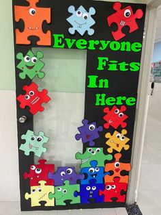 a door decorated with puzzle pieces and the words everyone fits in here