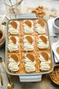 a pan filled with waffles covered in white frosting and caramel sauce