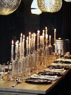 a long table with candles and plates on it