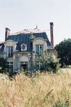 an old abandoned house is surrounded by tall grass