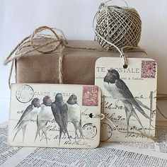 two tags with birds on them are sitting next to a box and some twine