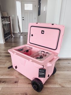 a pink cooler sitting on top of a hard wood floor