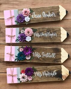 three wooden signs with flowers on them