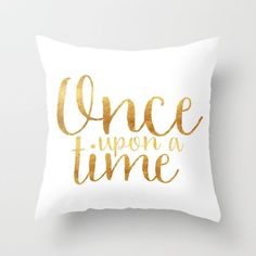 a white pillow with gold foil lettering that says once upon a time on the front