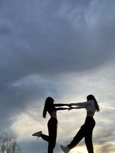 two young women are playing with each other in the park at sunset or sunrise time