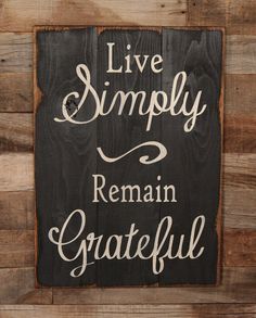a wooden sign that says live simply remain grateful on the side of a wood wall