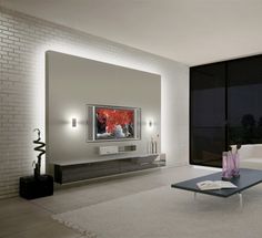 a living room filled with furniture and a flat screen tv sitting on top of a wall