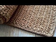 a close up view of a crocheted rug on a wooden floor